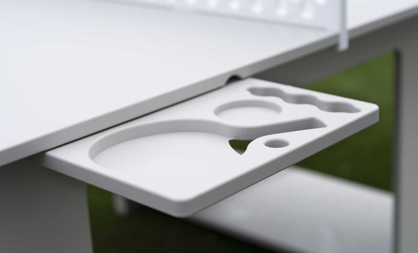 White pull-out side tray with molded drink and accessory holders beneath an outdoor ping pong table.