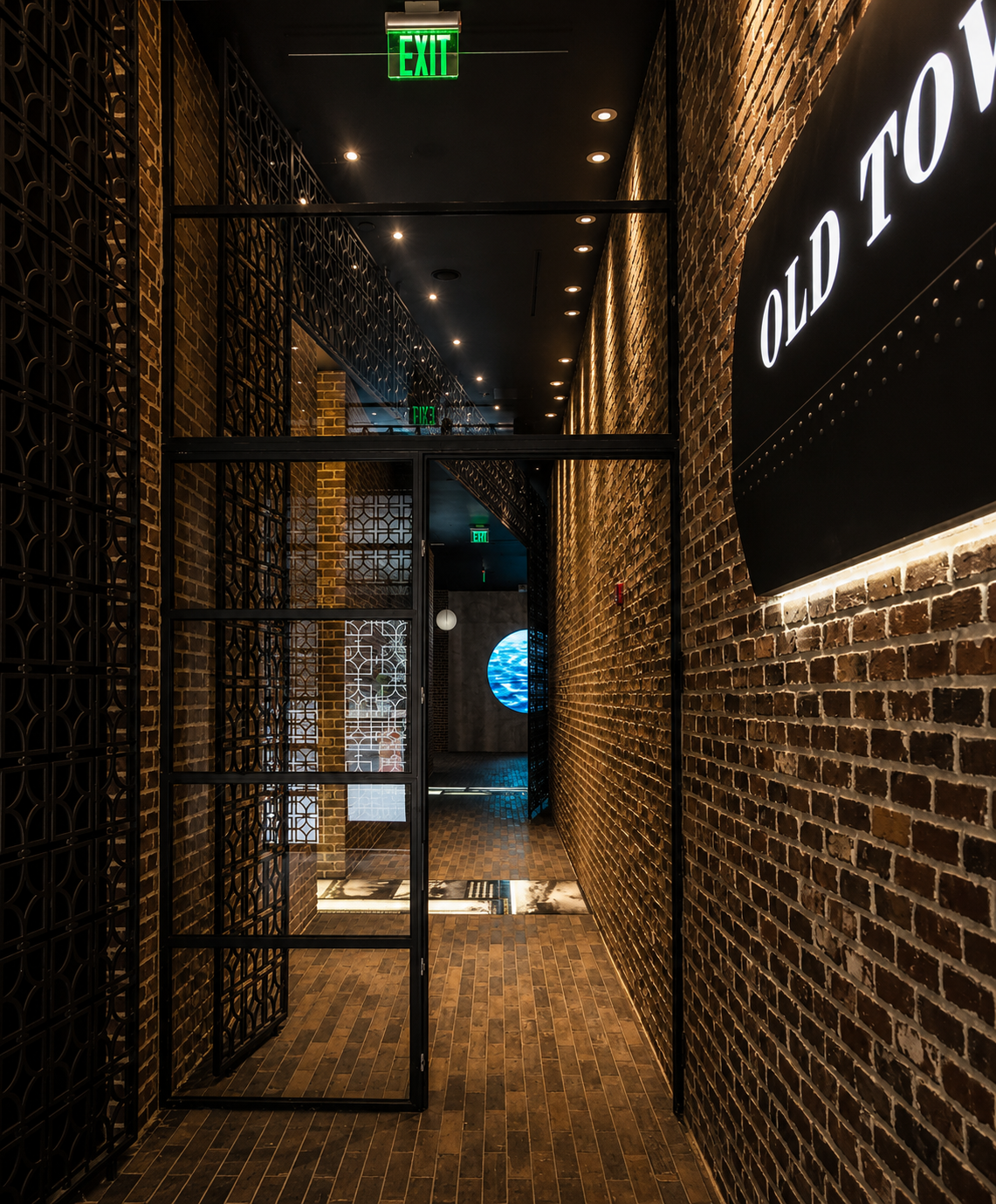Dark interior hallway with brick walls and a sign reading 'Old Town'.