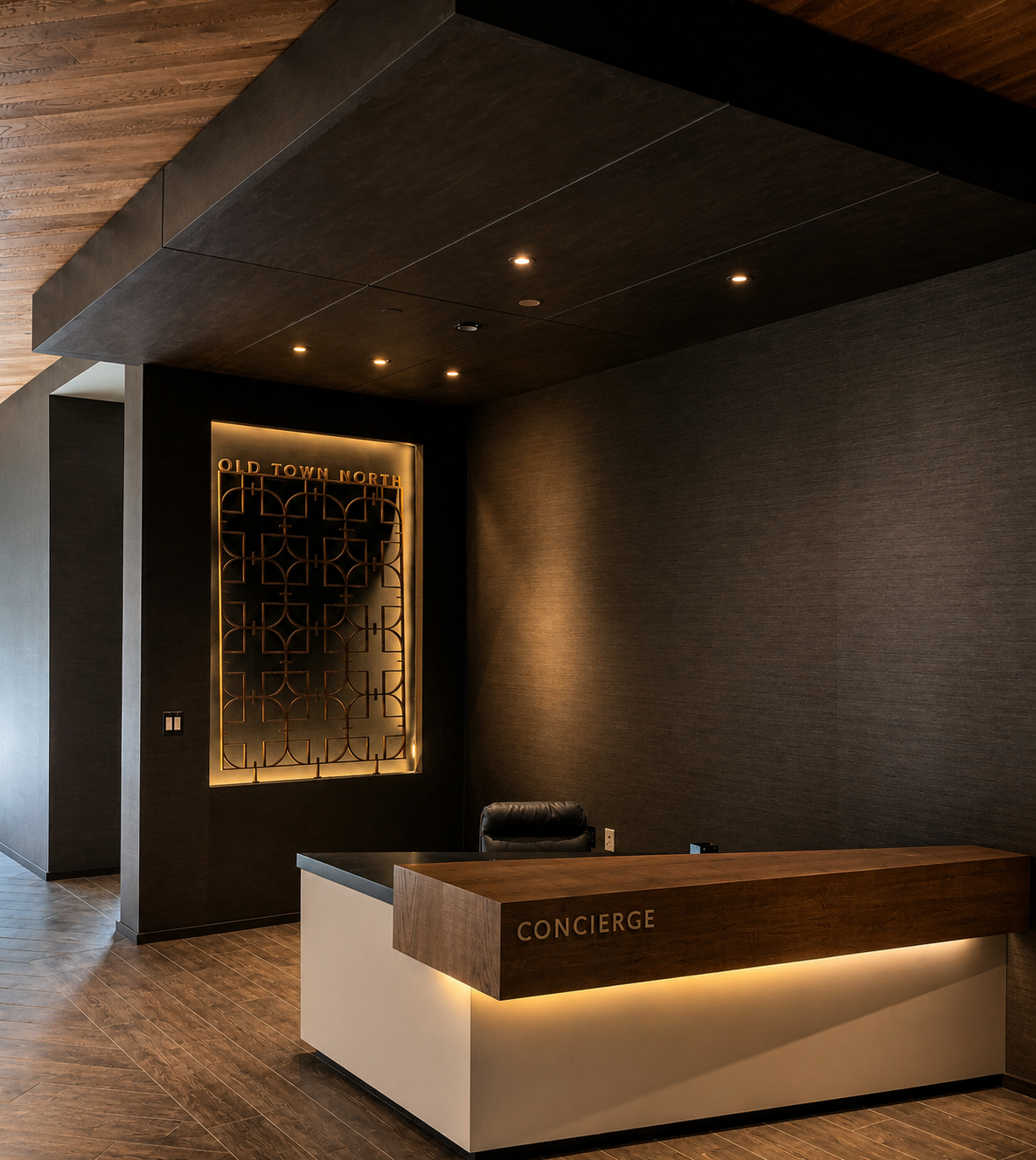Modern concierge desk in a dimly lit lobby with wooden accents.