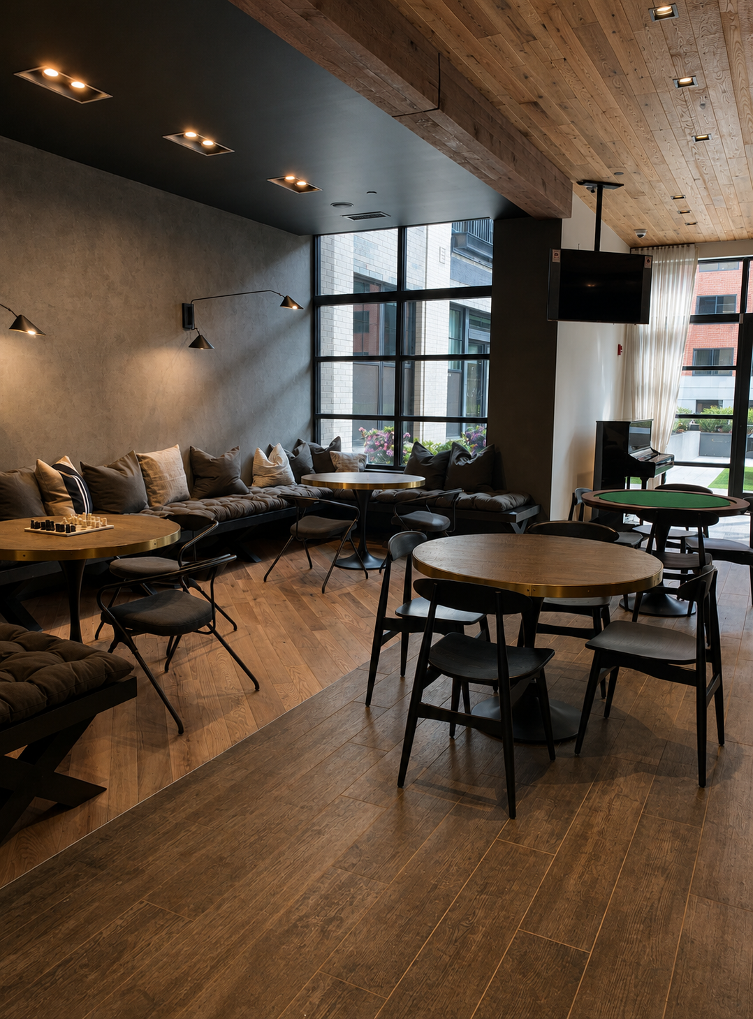 Modern interior of amenities of a multifamily building with wooden floors, tables, and chairs.