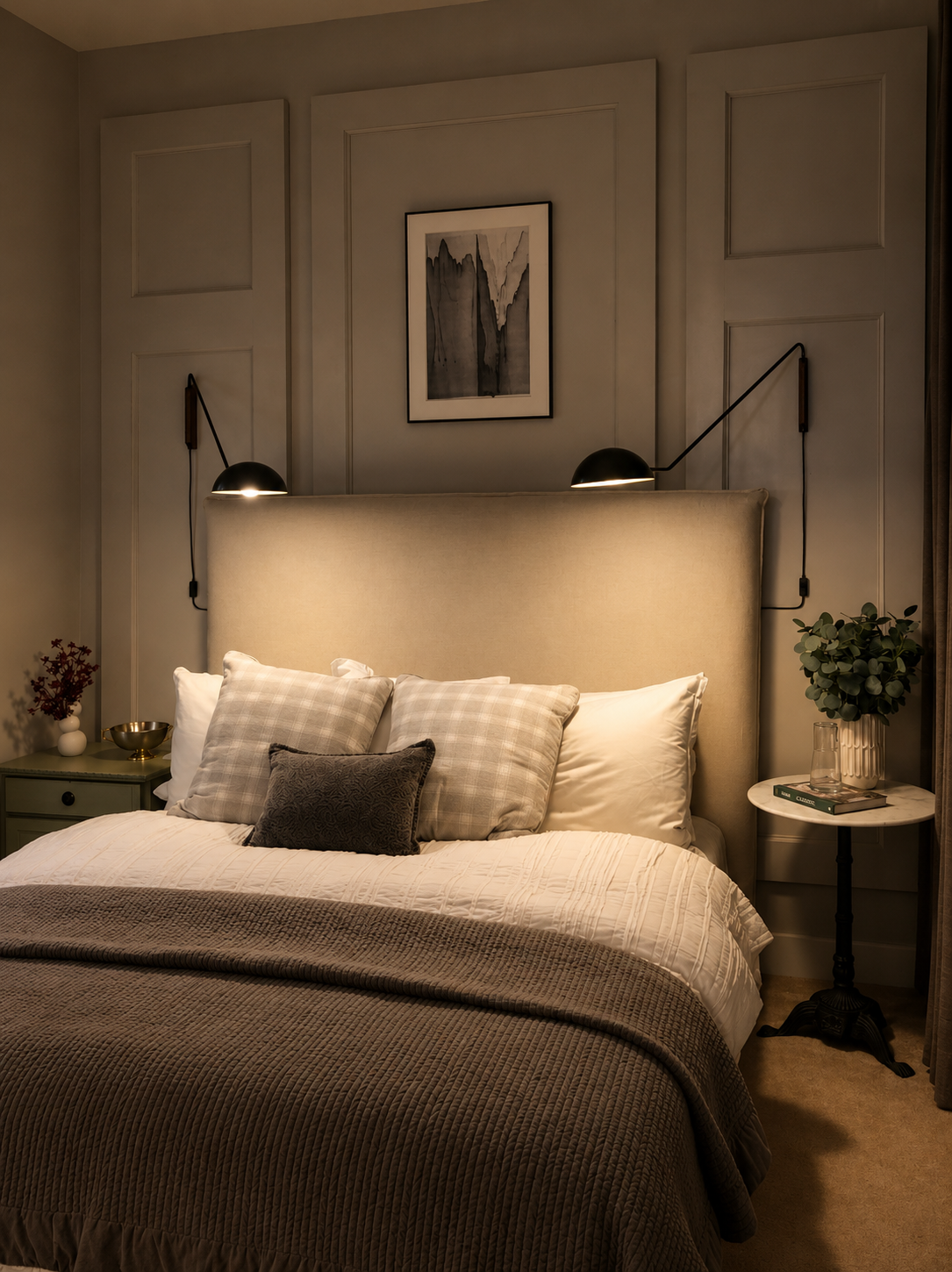 Cozy bedroom with a bed, side tables, and wall lights.