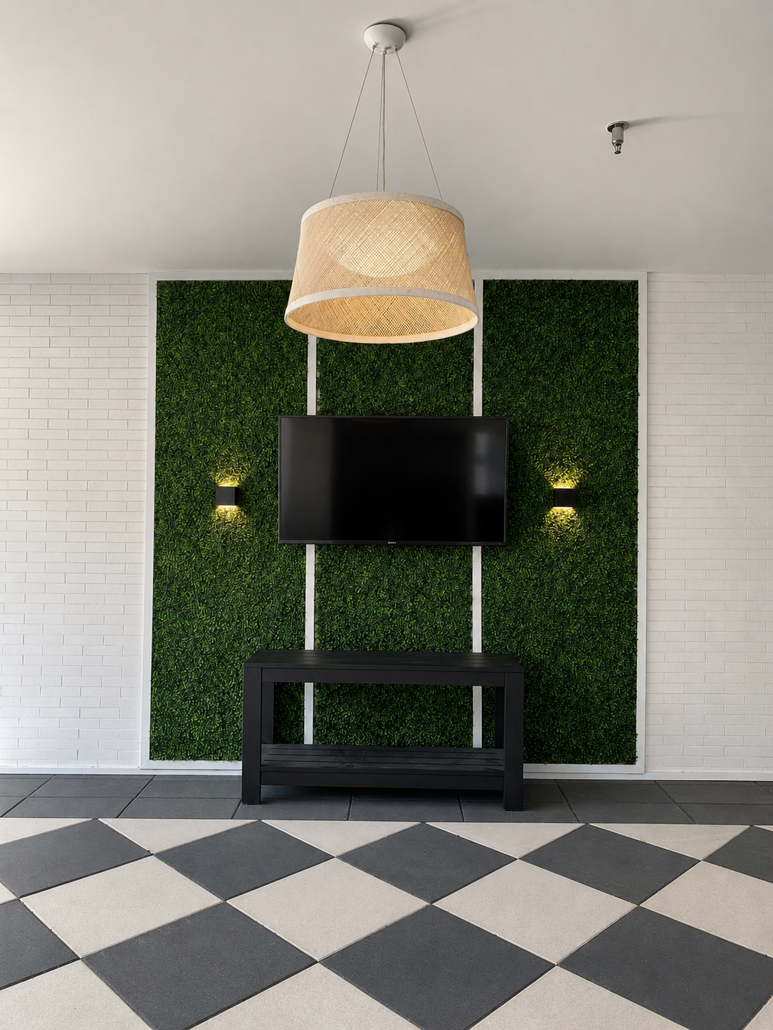 Modern outdoor covered area with a TV mounted on a green wall and a checkered floor.