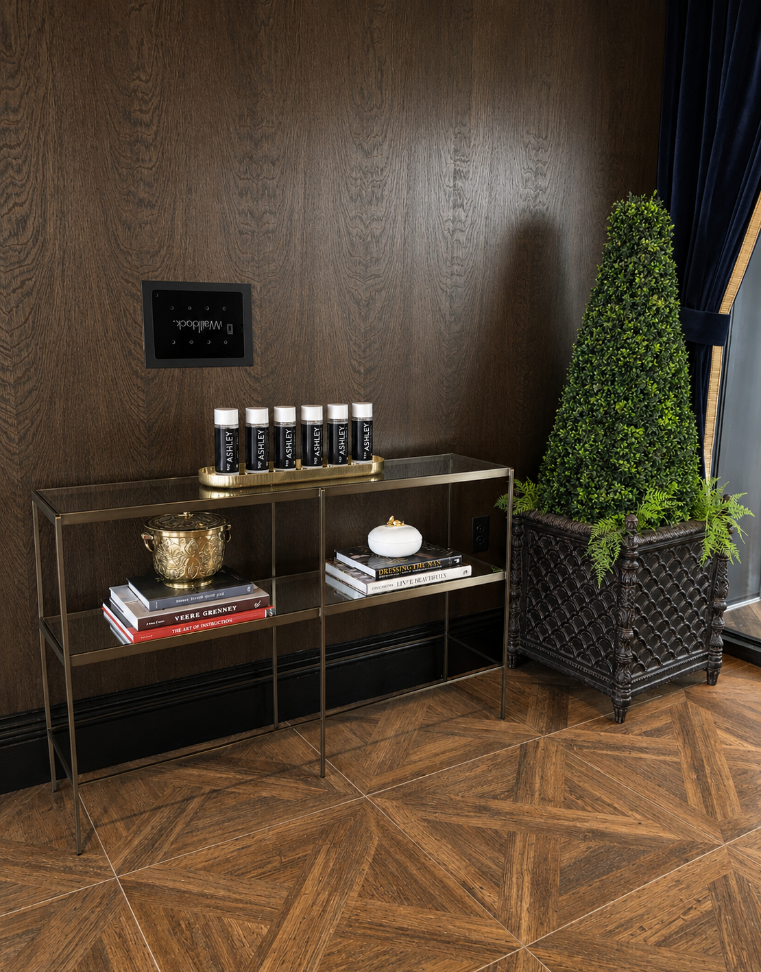 Decorative interior setting with a shelf, books, and a plant against a wooden wall.