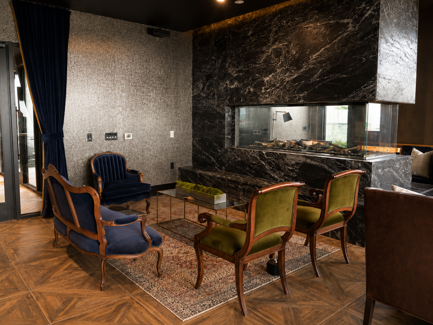 Luxurious interior with marble walls, wooden chairs, and a large mirror.