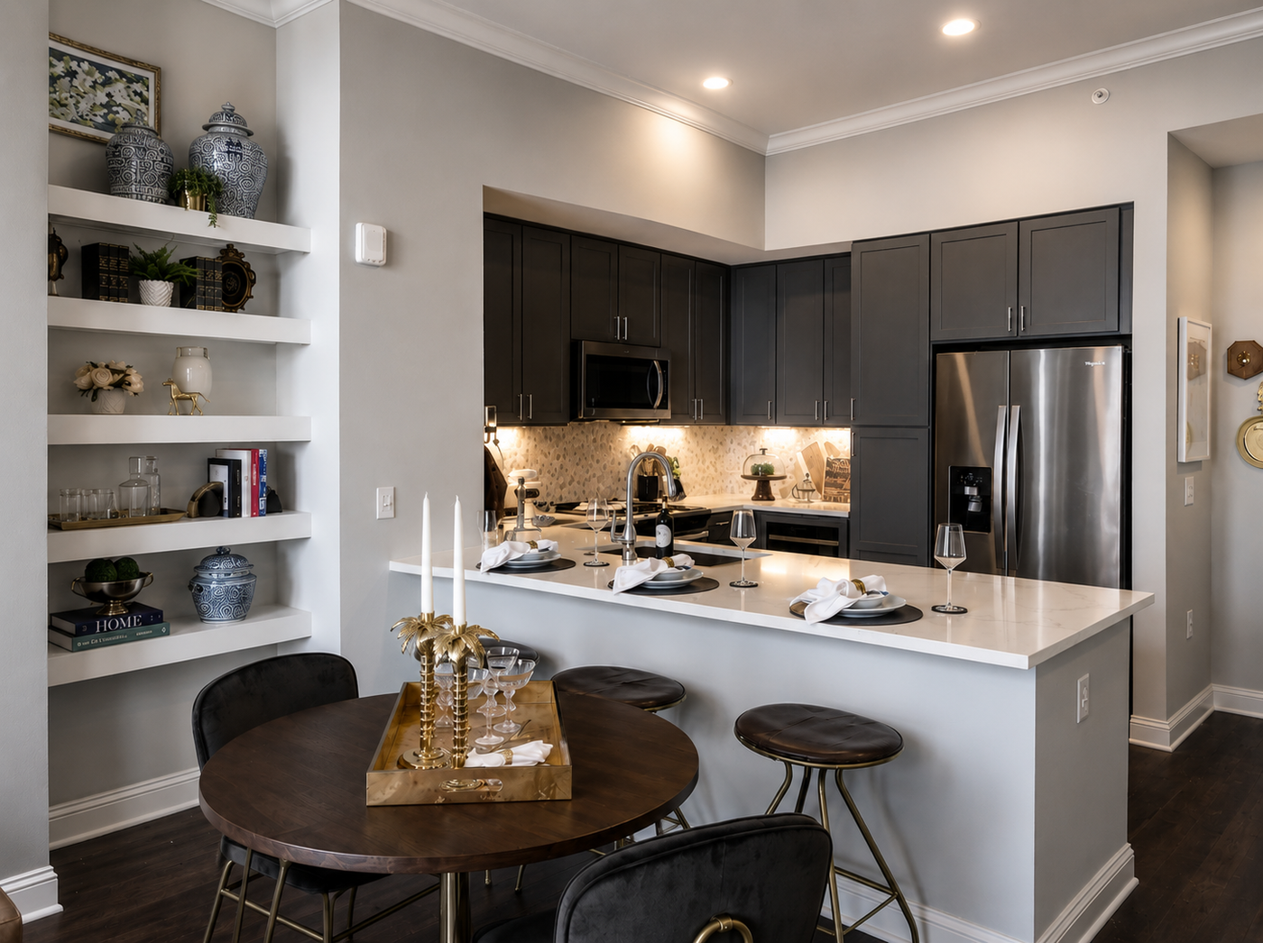 Modern kitchen with dark cabinets, stainless steel appliances, and a dining area.