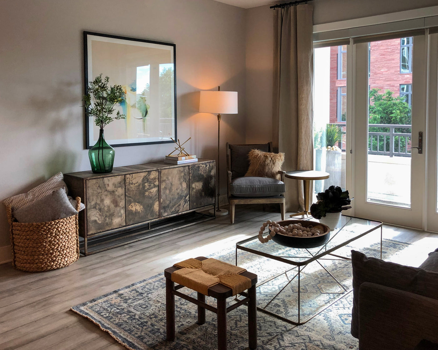 Living room with a glass coffee table, armchair, and decorative items.