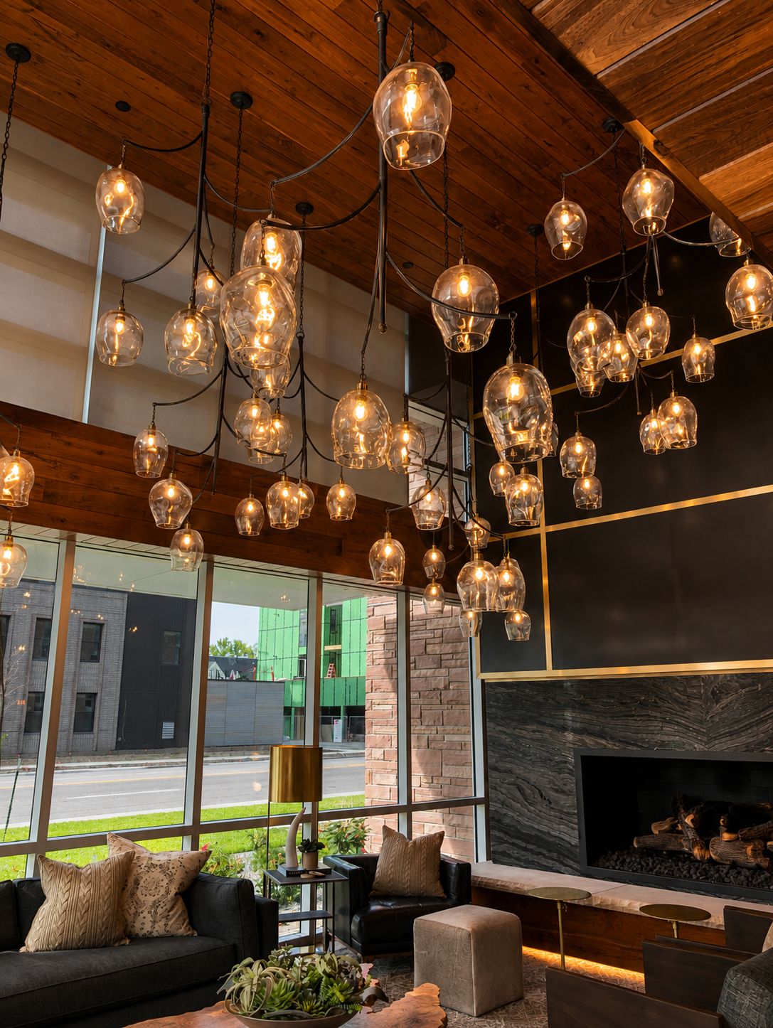 Modern leasing area with hanging glass pendant lights, a fireplace, and large windows.