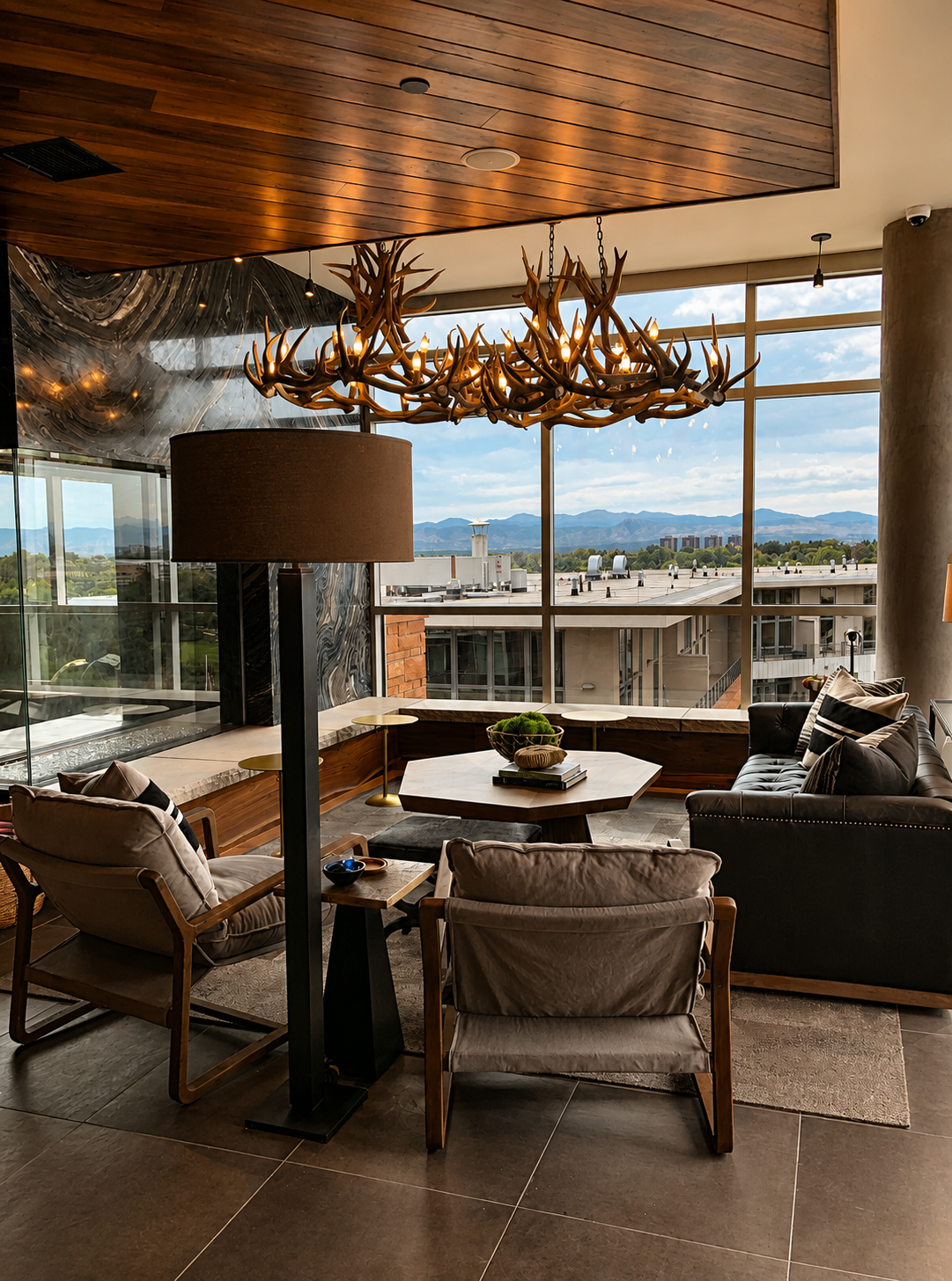 Modern waiting area with large windows, wooden furniture, and a chandelier.