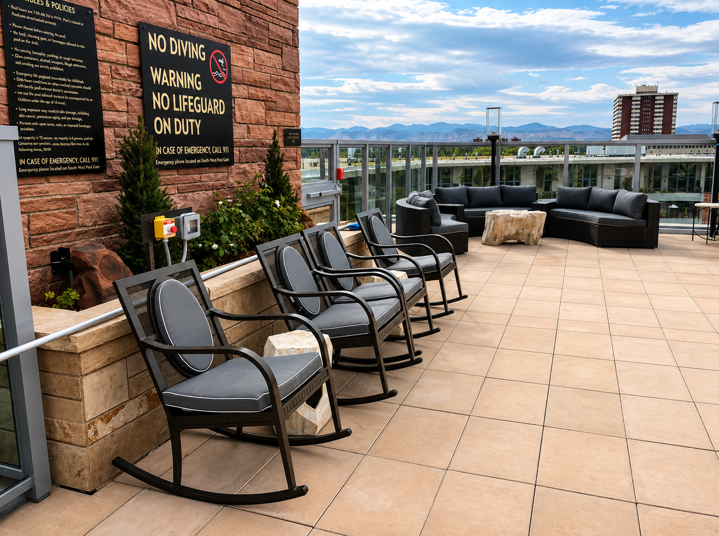 Outdoor seating area with chairs and couches on a rooftop with a cityscape view.