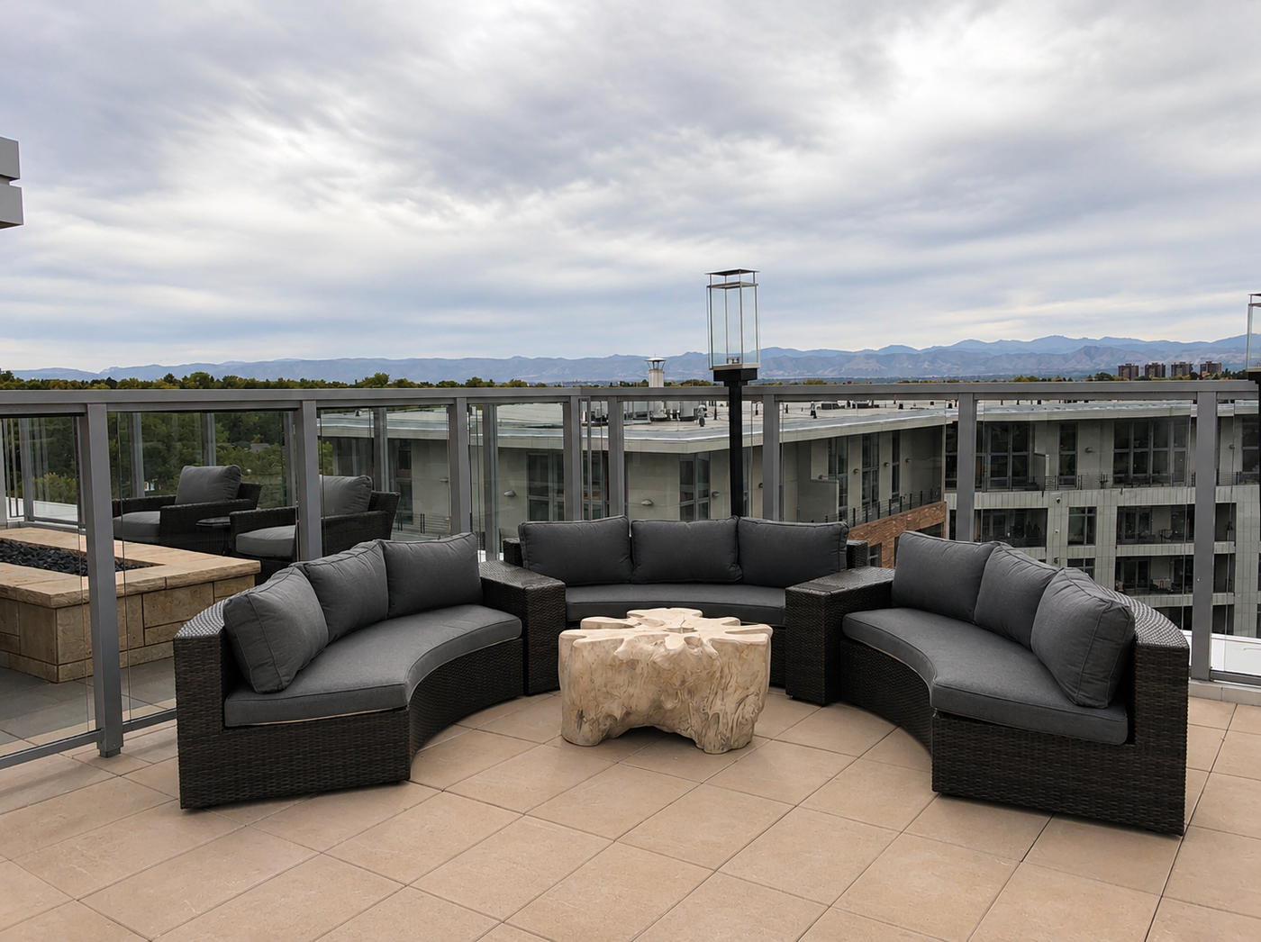 Outdoor patio furniture set on a rooftop with a cityscape in the background