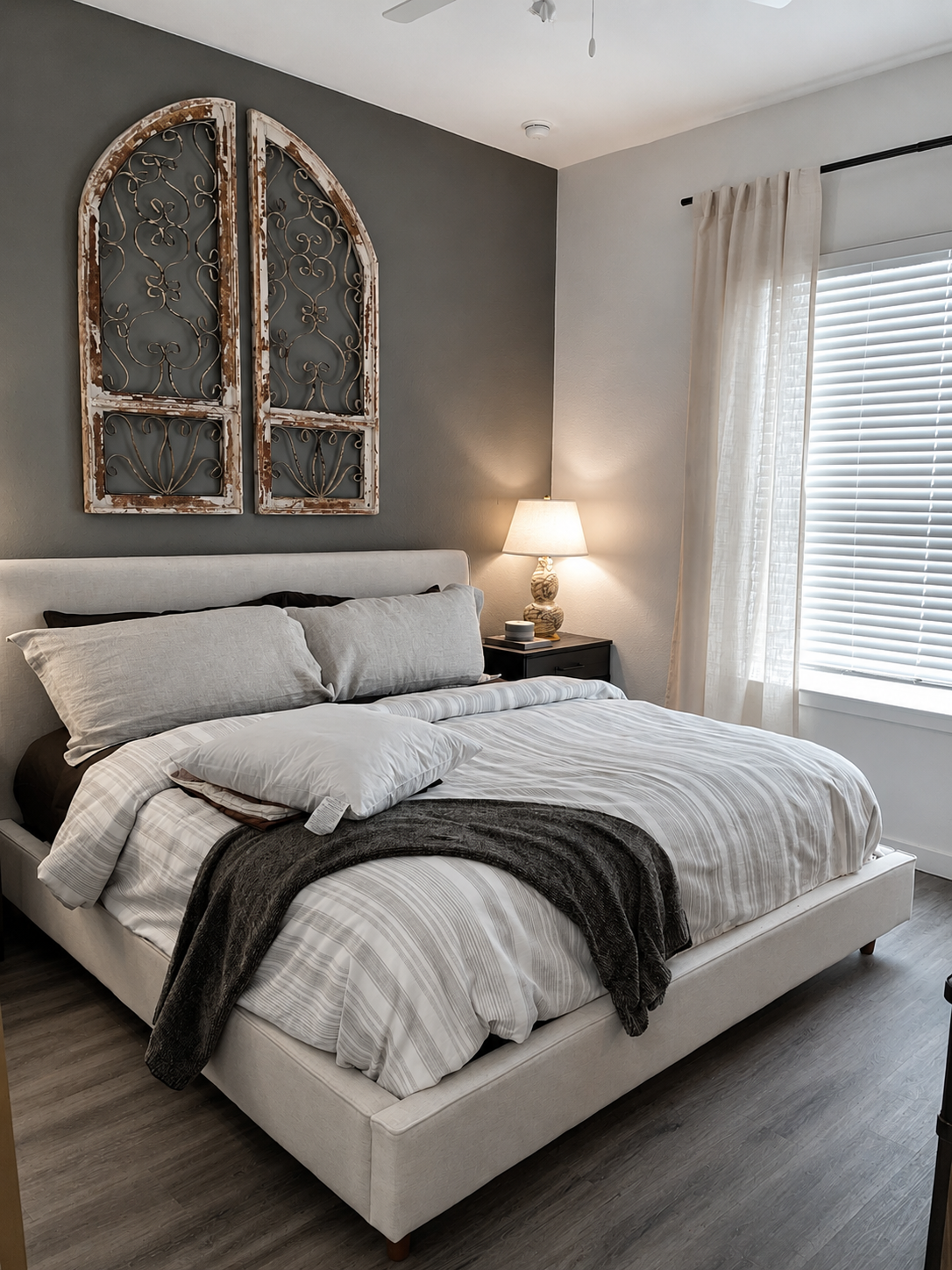 Modern bedroom with a bed, decorative wall art, and a lamp.