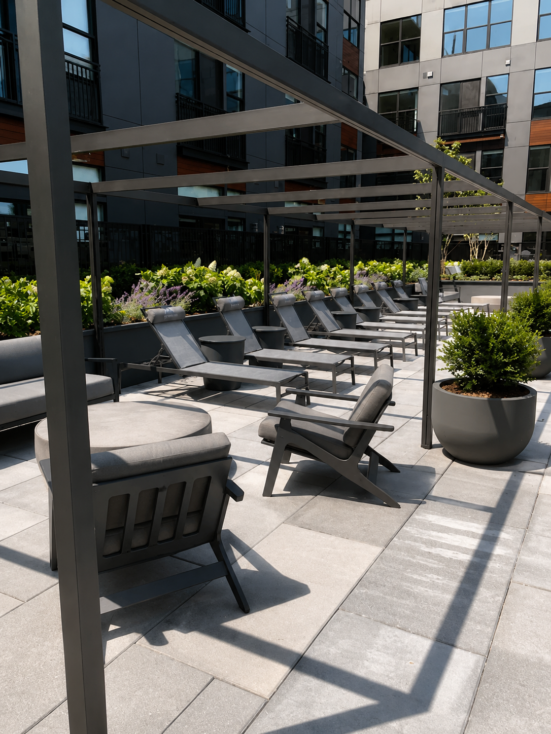 Outdoor seating area with lounge chairs under an awning in an urban setting