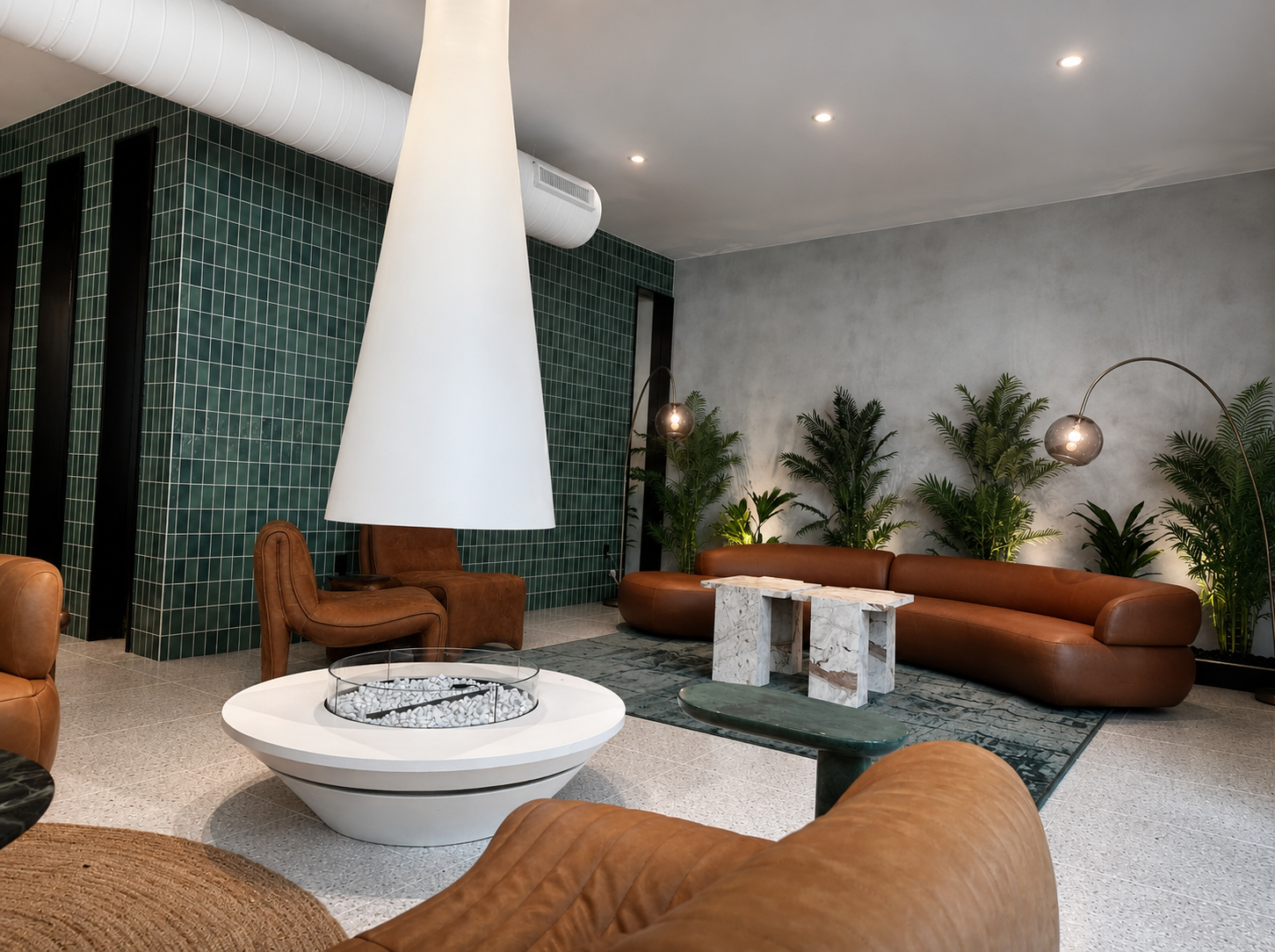 Modern amenities for multifamily with brown leather furniture, a white fire pit table, and decorative plants.