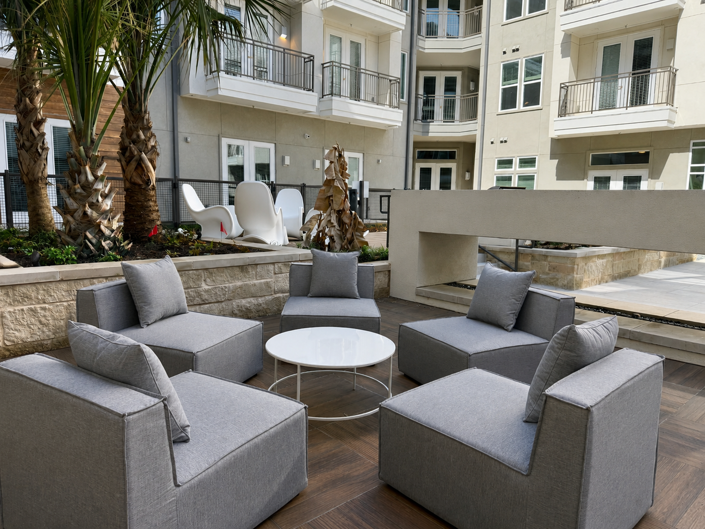 Outdoor seating area with gray chairs and a table in front of a building.