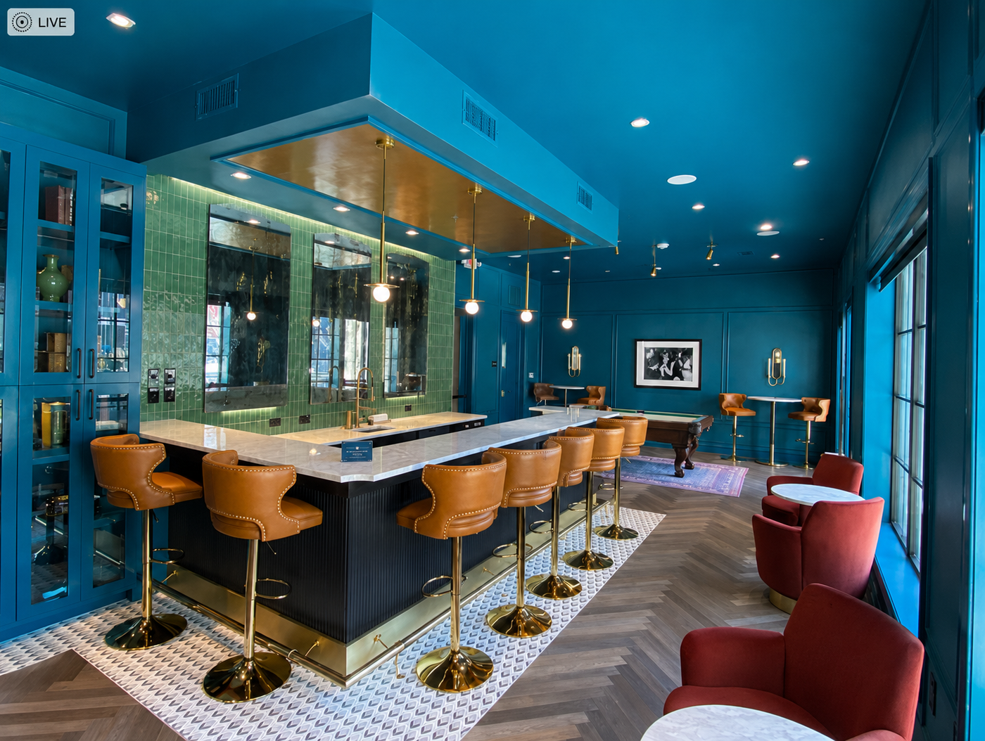 Modern bar with blue walls, white countertops, and brown bar stools.