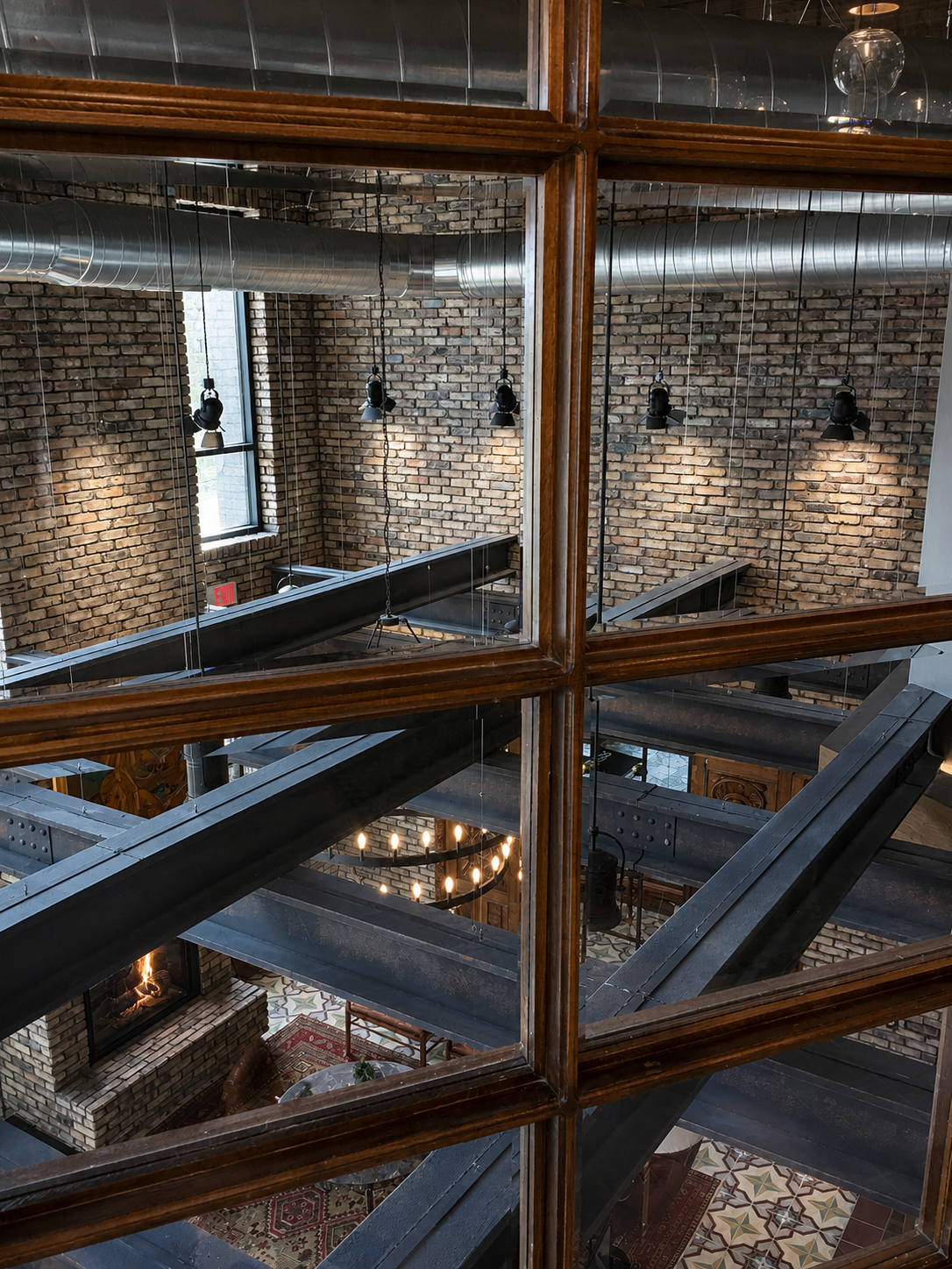 Indoor setting with brick walls, wooden beams, and a large mirror reflecting the room.