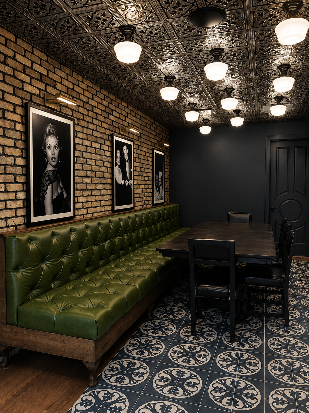 Green leather booth in a dimly lit room with brick walls, framed pictures, and patterned floor.