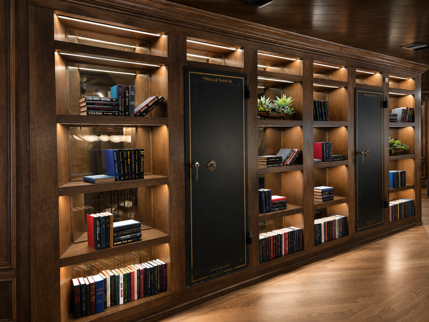 Wooden bookshelf with books and decorative items in a dimly lit room, with two vault doors embbeded. 